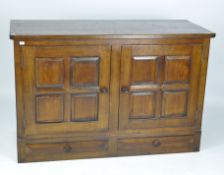 A two door stained oak storage cupboard, each door opening to reveal sliding drawers,
