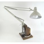 A vintage anglepoise style lamp, mounted on wooden base,