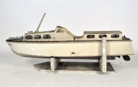 A vintage pond speed boat, named to front 'Monica', mounted on a wooden stand,