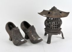 A cast iron planter modelled as a pagoda, together with a pair of iron planters