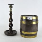 An oak coppered barrel, height 20cm, together with a turned barley twist candlestick,