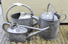 Three galvanised watering cans, one marked HAWS,