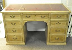 A late 19th/early 20th century pine pedestal desk, the leather top with gilt tooled borders,