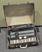 A vintage Frontalini accordian, in black and chrome finish and in a red case,