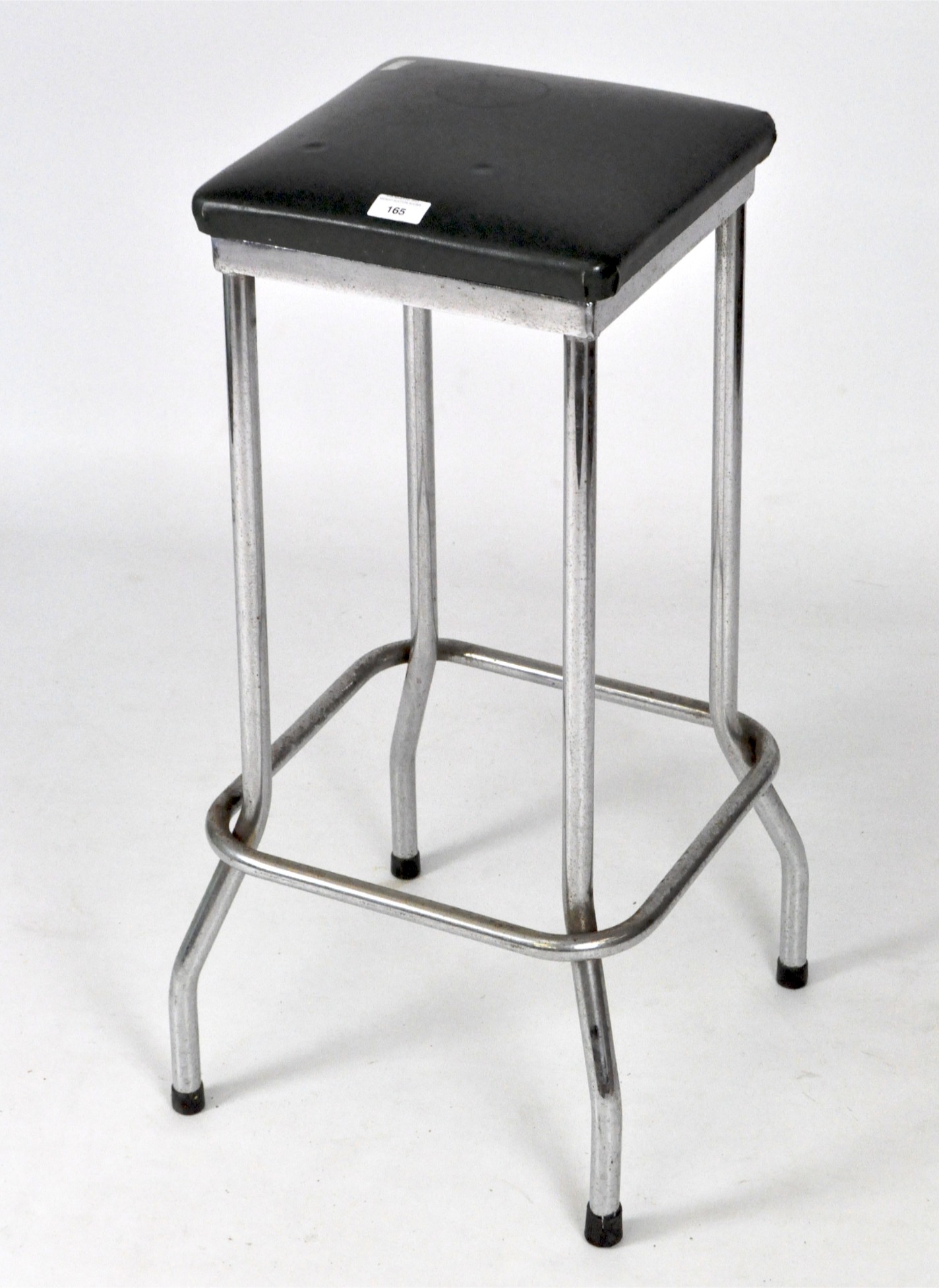 A tubular chromed stool, with green leatherette top