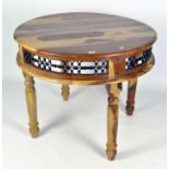 A contemporary circular wooden table, with pierced metal frieze, on turned baluster legs,