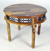 A contemporary circular wooden table, with pierced metal frieze, on turned baluster legs,