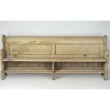 A large early 20th Century pine pew/bench, with a book rest to the reverse,