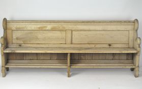 A large early 20th Century pine pew/bench, with a book rest to the reverse,