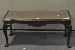 A contemporary stained wooden coffee table, with gilt tooled leather top,