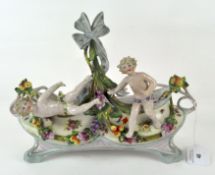 A French ceramic planter, modelled as two putti surrounded by fruit and gilt scrolls,