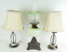 An Edwardian oil lamp with etched green glass shade,