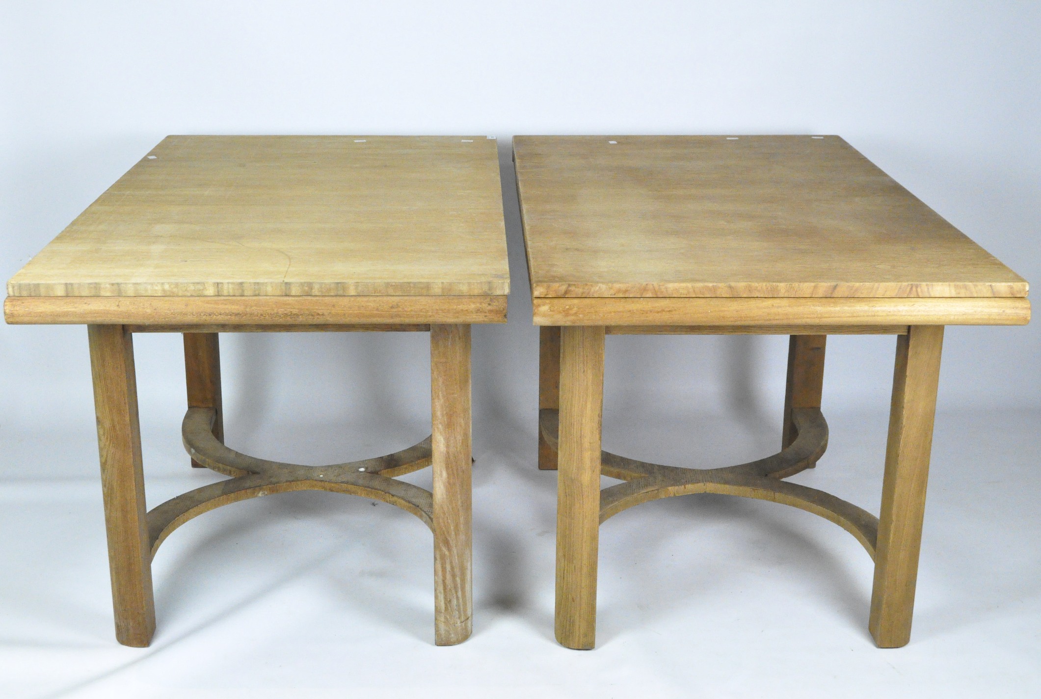 A pair of extendable pine dining tables, with cross banding supports,