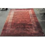 A large oriental floor rug, red in colour,
