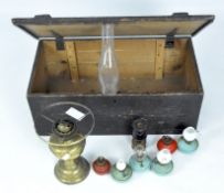 A Victorian brass oil lamp and assorted accessories in a hinged wooden trunk