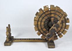 An unusual Indian teak spinning wheel, adorned with studded metal mounts,