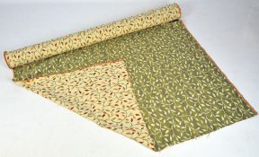 A roll of upholstery fabric, decorated with leaves,