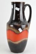 A West German pouring vessel glazed in brown and orange,