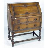 An early 20th century oak bureau, the drop front over two long drawers,