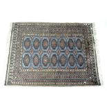 A blue ground Oriental style rug with geometric central medalions.