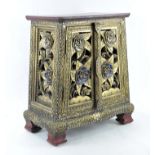A contemporary table top cabinet, elaborately decorated with carved flowers,