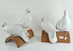 Two pairs of white ceramic doves, mounted on roof tiles,