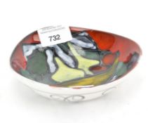 A mid-century Art Pottery dish, printed WV mark, glazed with abstract fruits, on a red ground,