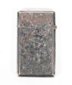 A late Victorian silver card case of rectangular form, adorned with chased foliate scrolling,