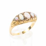 An 18ct gold and opal ring, set with graduated line of oval cut opals to a scrolling setting. 1.6g.