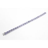 A 14ct white gold tanzanite and diamond 'riviere' line bracelet.