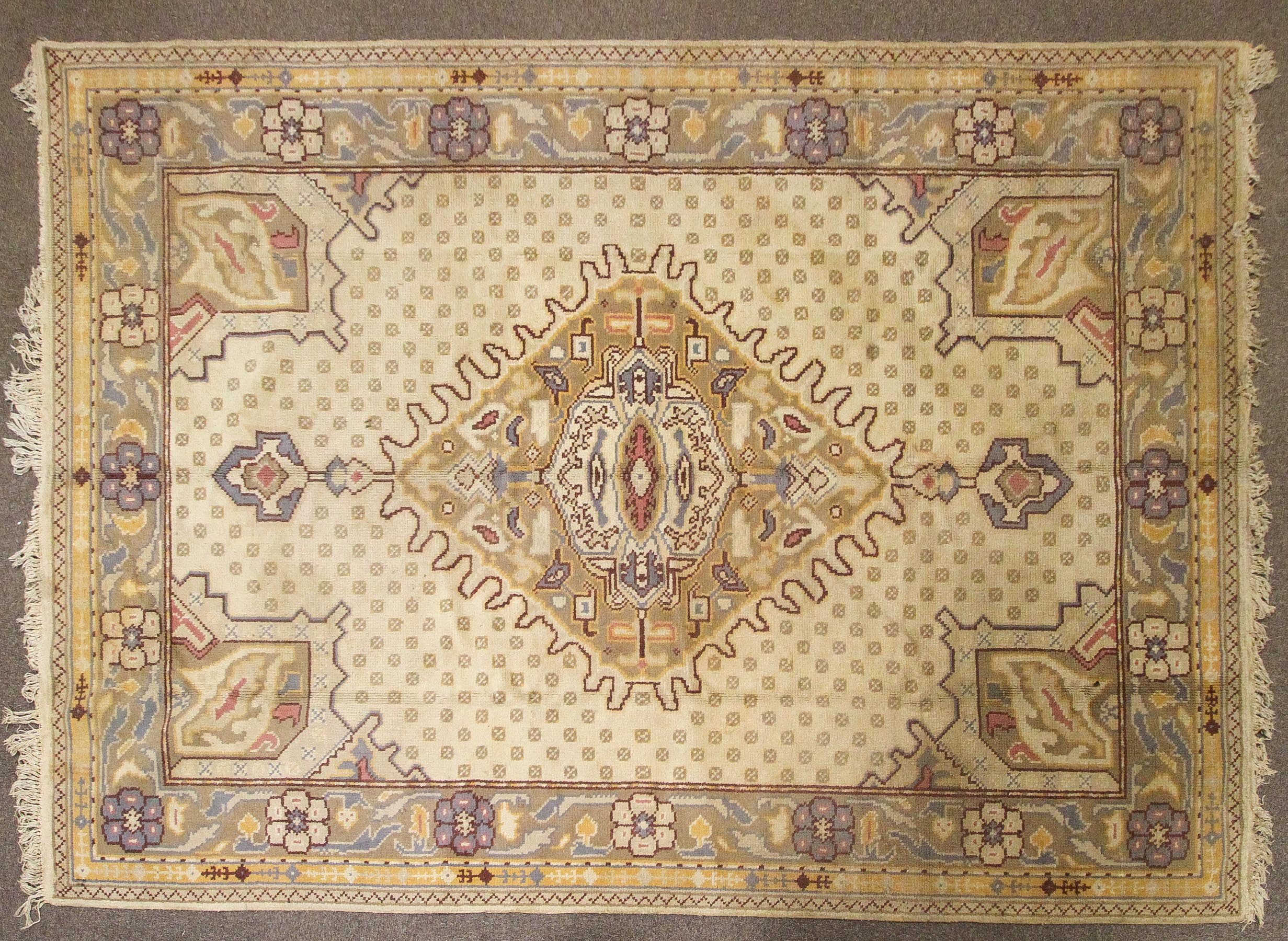 An Oriental style wool rug, cream ground with central geometric medallion,