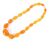 A graduated strand of honey coloured amber-style Bakelite beads. 100cm.