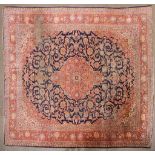 A large Persian silk/wool rug red ground with central floral panel and three floral; borders.