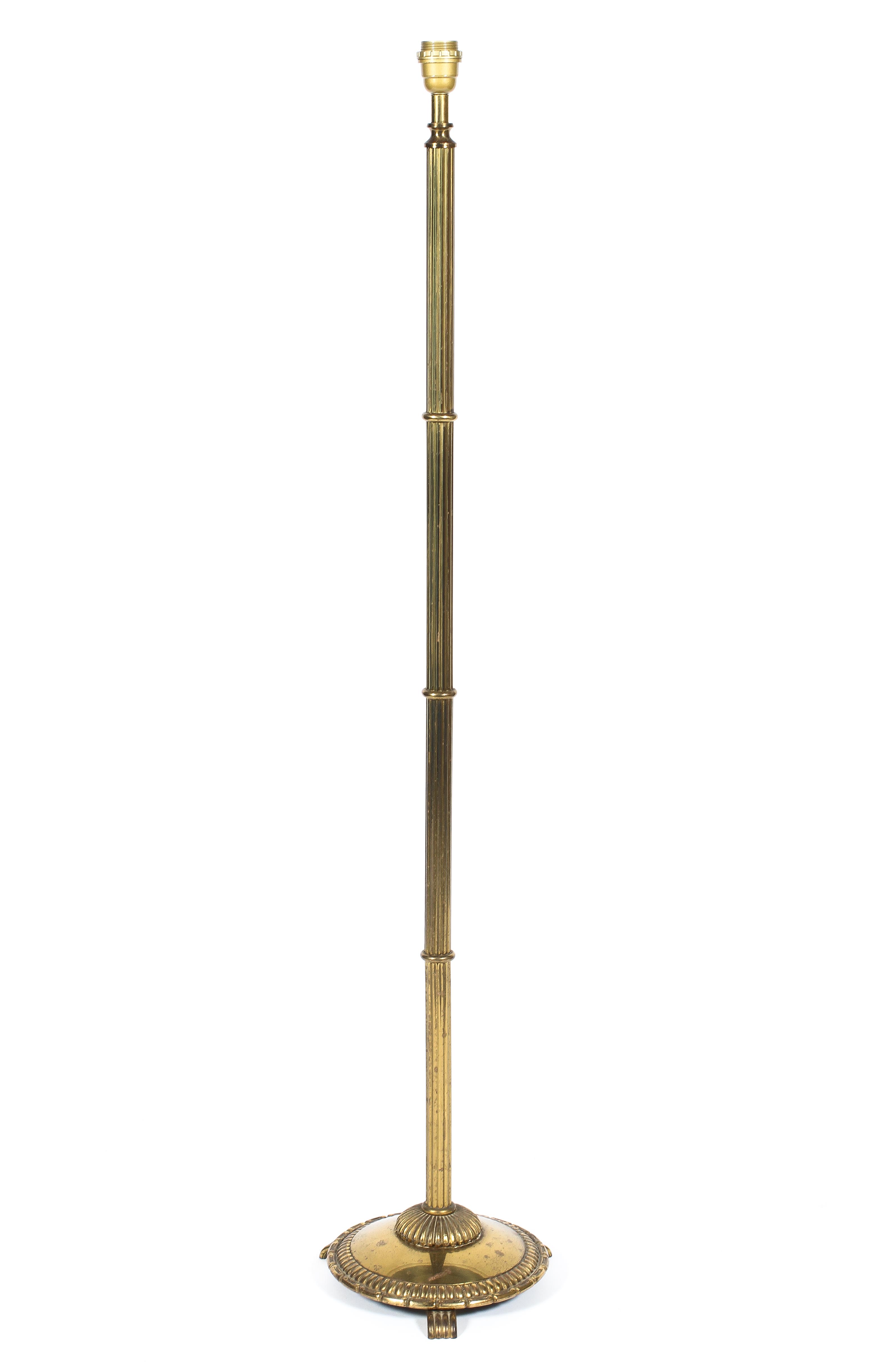 A brass standard lamp, 20th century, with reeded column on gadrooned circular base with scroll feet,