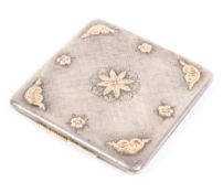 An early 20th century silver compact, the lid with engraved details and foliate gilt mounts,