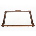 An antique veneered rectangular overmantle mirror, the shaped frame with inlaid details,