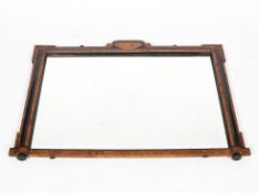 An antique veneered rectangular overmantle mirror, the shaped frame with inlaid details,