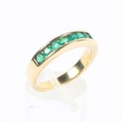 An 18ct gold and emerald ring chanel set with 9 single cut emeralds. 5.5g. Size O.