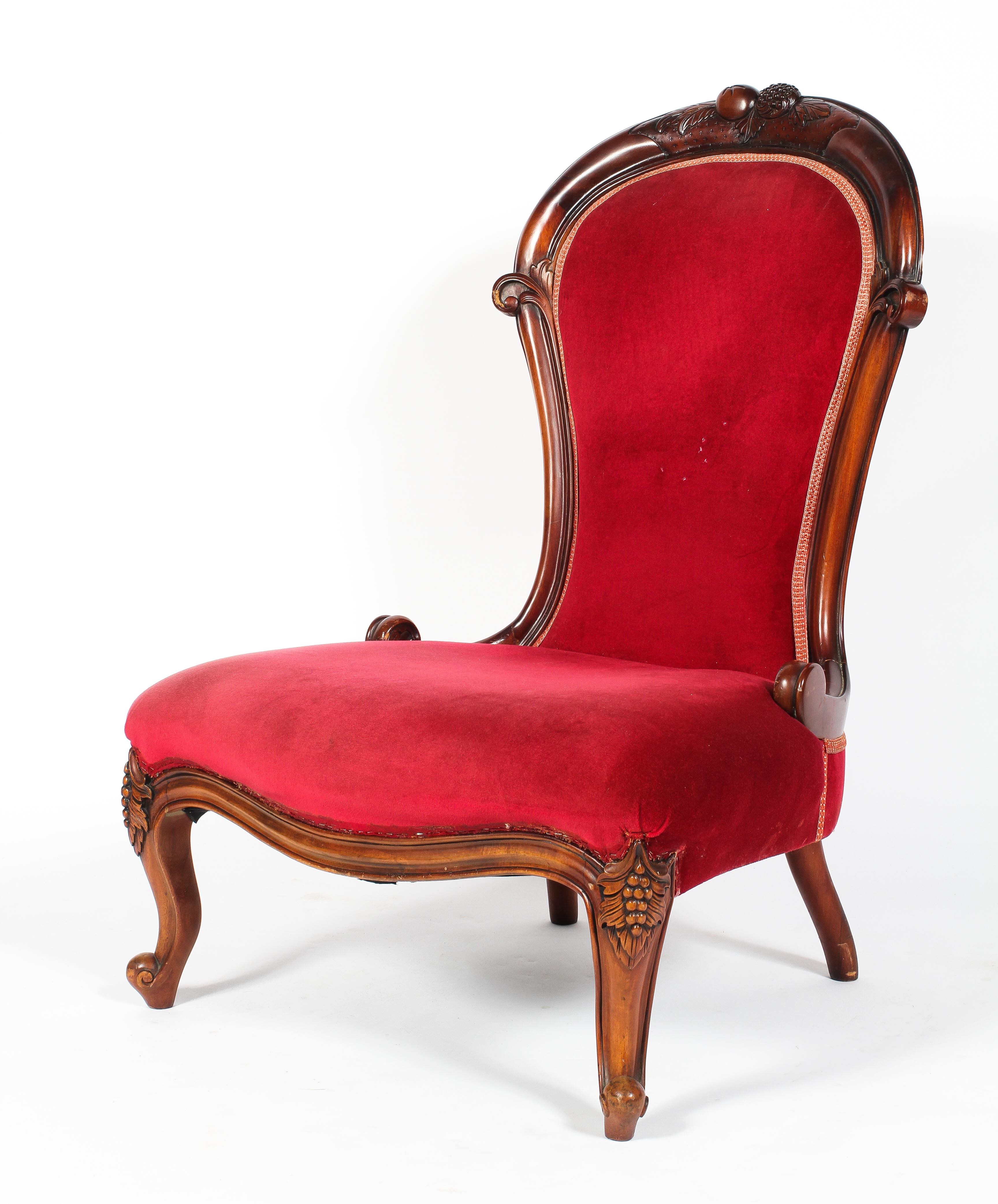 A Victorian carved mahogany nursing chair, the balloon shaped back carved with fruits,