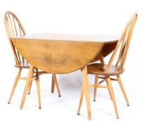 An Ercol light elm and beech drop-leaf dining table and two spindle back chairs on splayed feet,