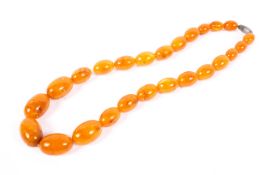 A strand of graduated honey amber-style Bakelite beads 124g. 64cm.