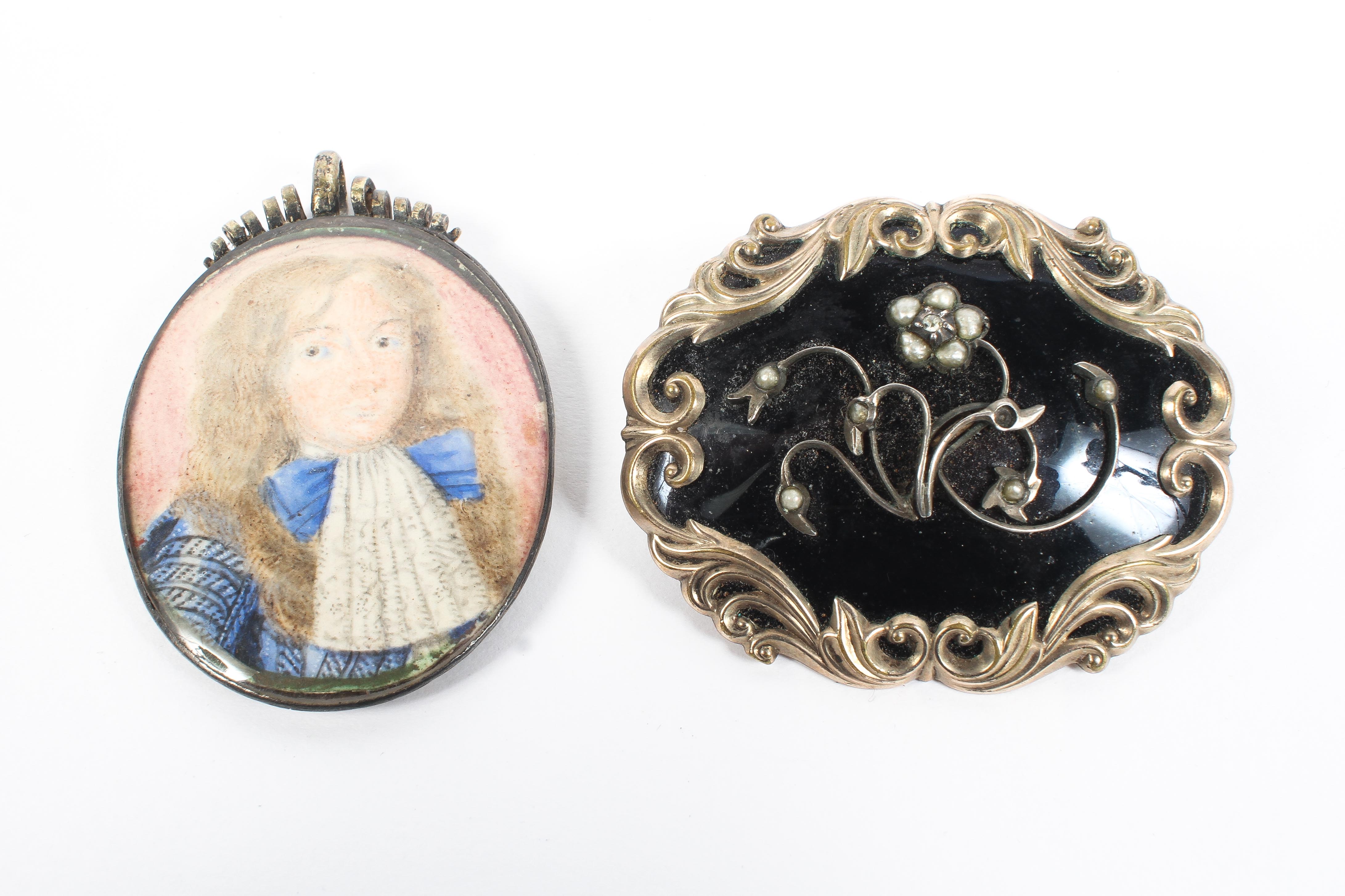 A black enamel and gilt metal mourning brooch set with seed pearl flowers and rose cut diamond