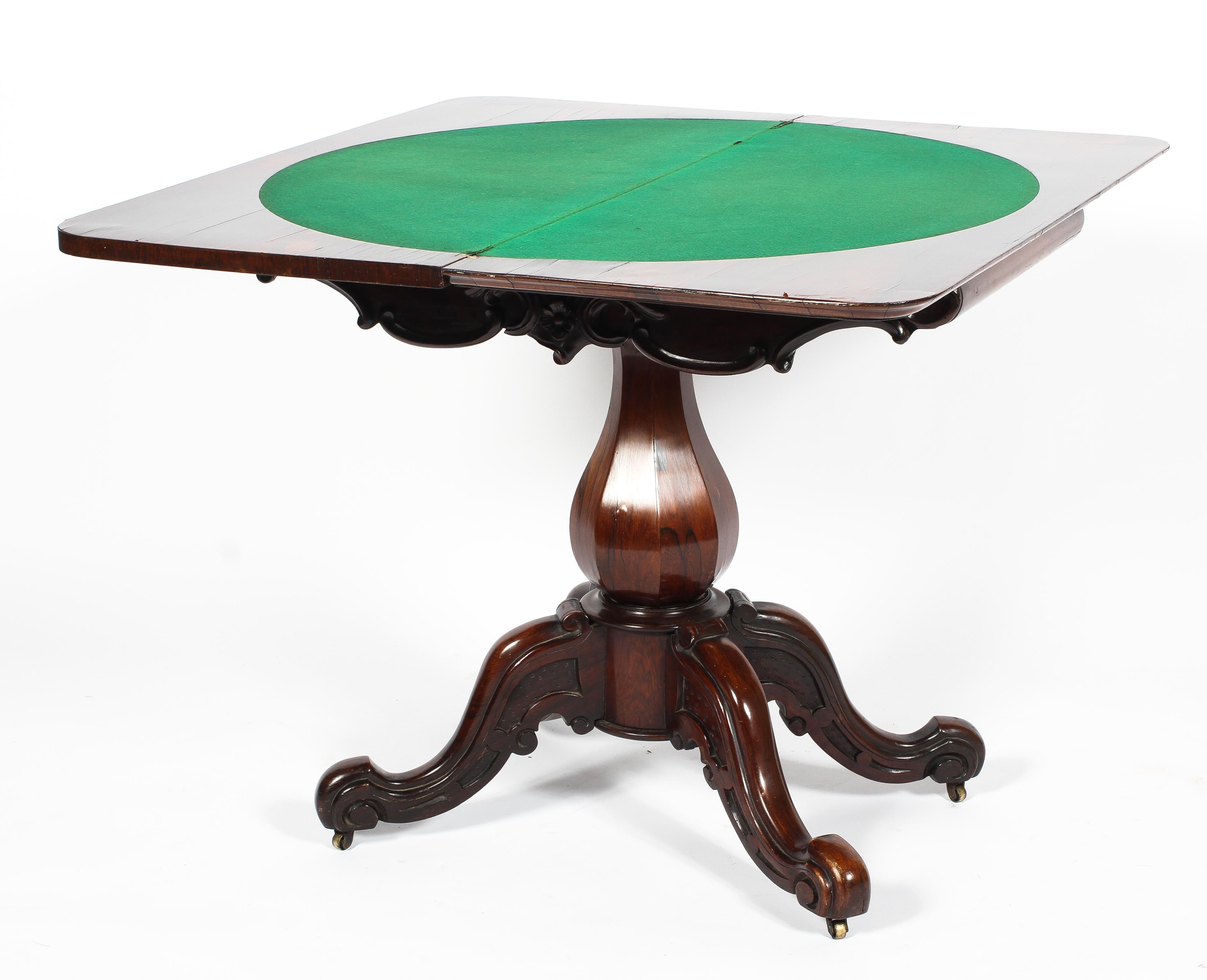 A Victorian carved rosewood card table, the moulded folding top inset with circular green baize,