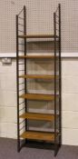 A retro Ladderax style shelving unit, with two brown ladder supports and six short veneered shelves,