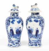 A pair of 19th century blue and white lidded vases decorated with two groups of scholars