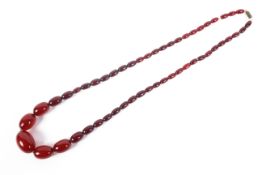 A graduated strand of cherry amber-style Bakelite beads. 72cm.