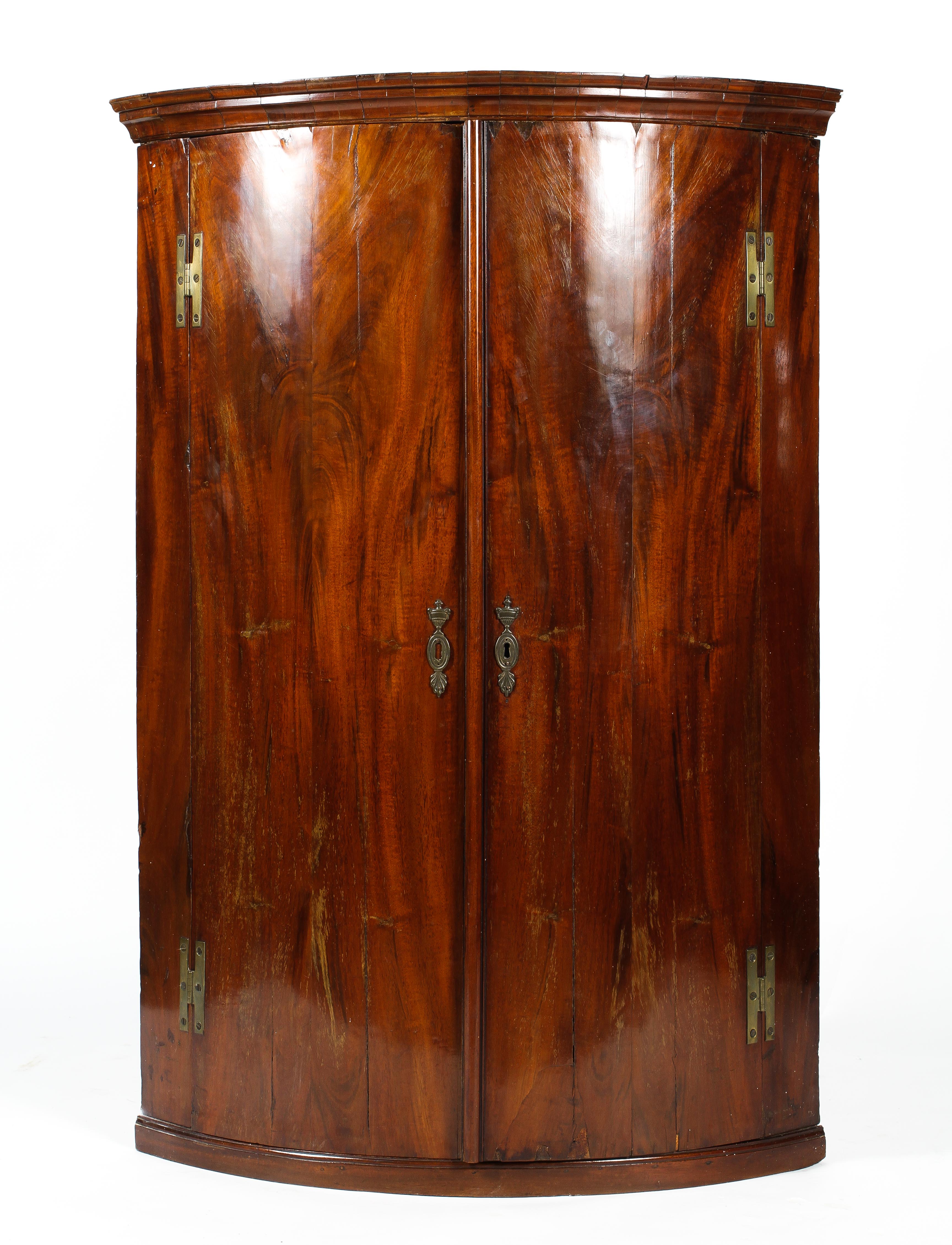 A large Georgian mahogany corner cabinet, d-shaped,