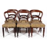 A set of six Victorian mahogany balloon-back dining chairs, with carved foliate back rest,