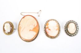 Four shell cameo brooches in unmarked yellow metal mounts.
