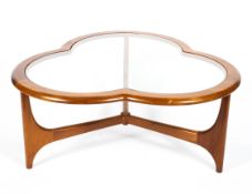 A mid-century golden oak clover leaf-shaped glass topped coffee table, joined by a cross stretcher,